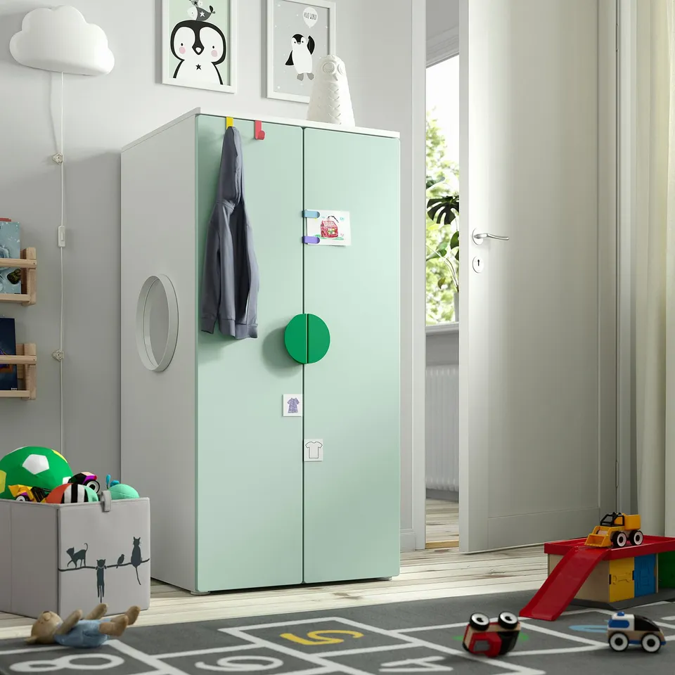 Kids room with green SMÅSTAD wardrobe, toys, and black rug.