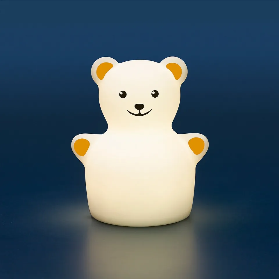 Teddy bear night light, color-changing, sits on surface.