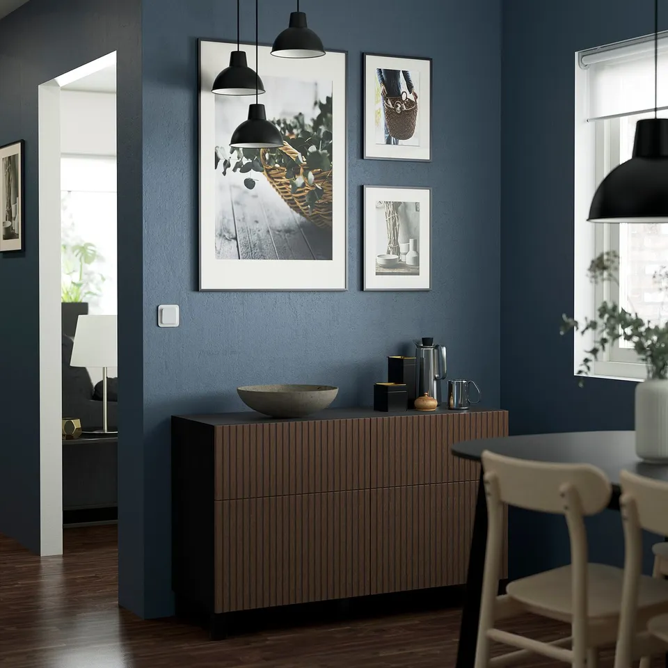 Modern blue room with BESTÅ drawers, bowl, pitcher, three framed pictures, and white chair.