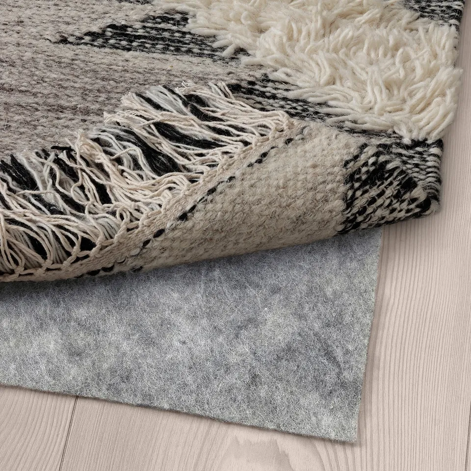 Rug with fringe on wooden floor.