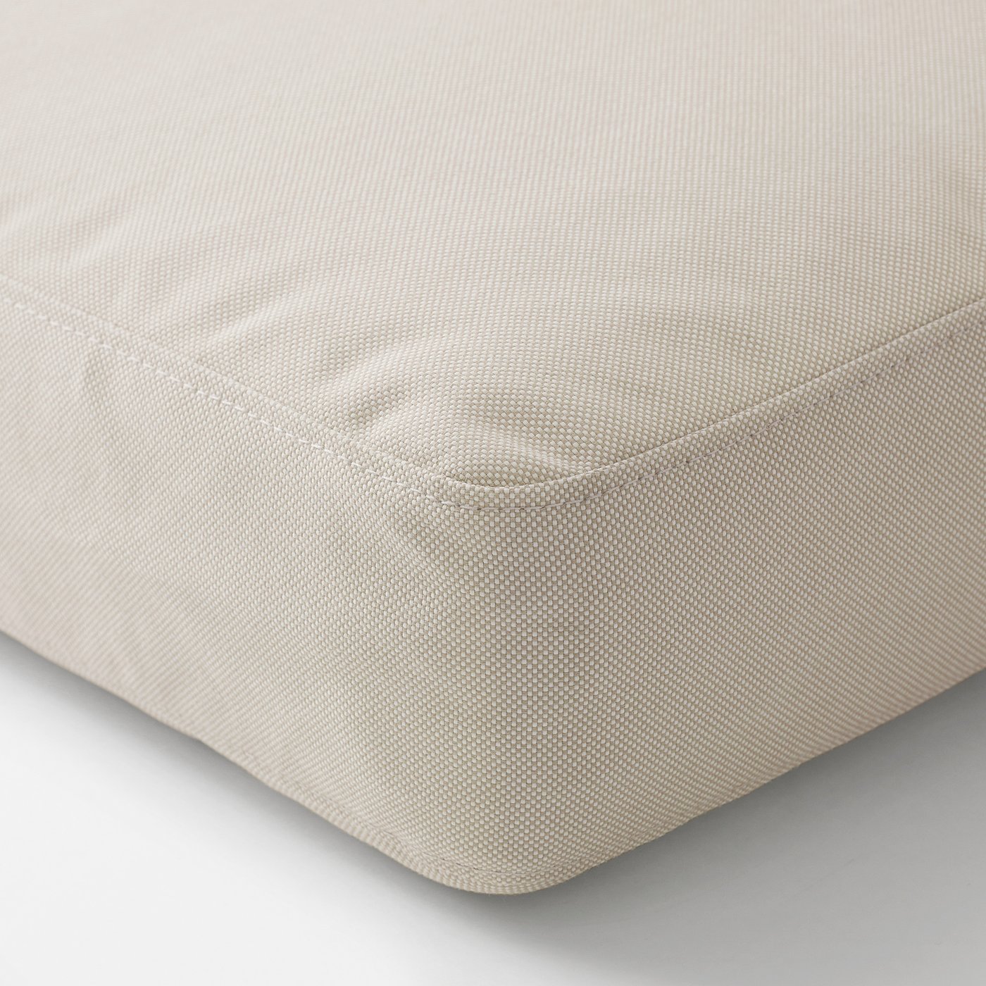 Close-up of a beige cushion, showcasing its soft, textured fabric and well-crafted edges.