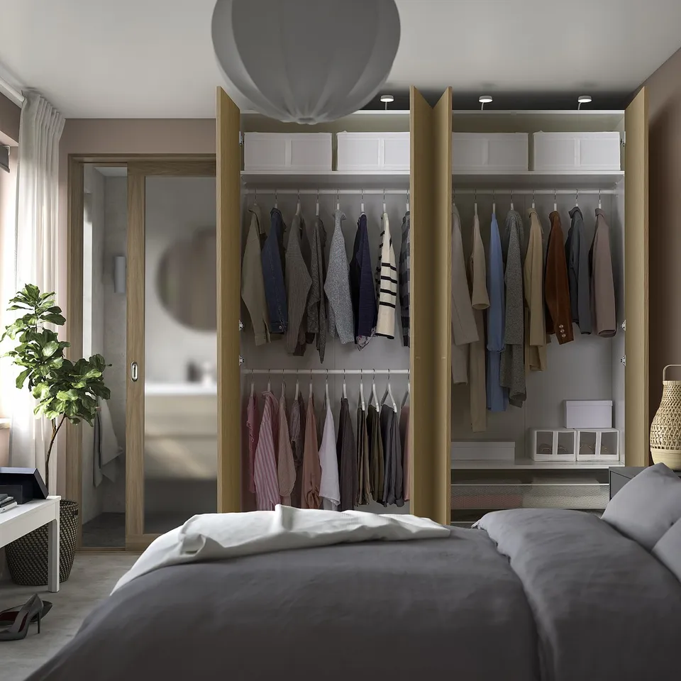 Organised bedroom with PAX wardrobe, clothes, drawers, and lights.