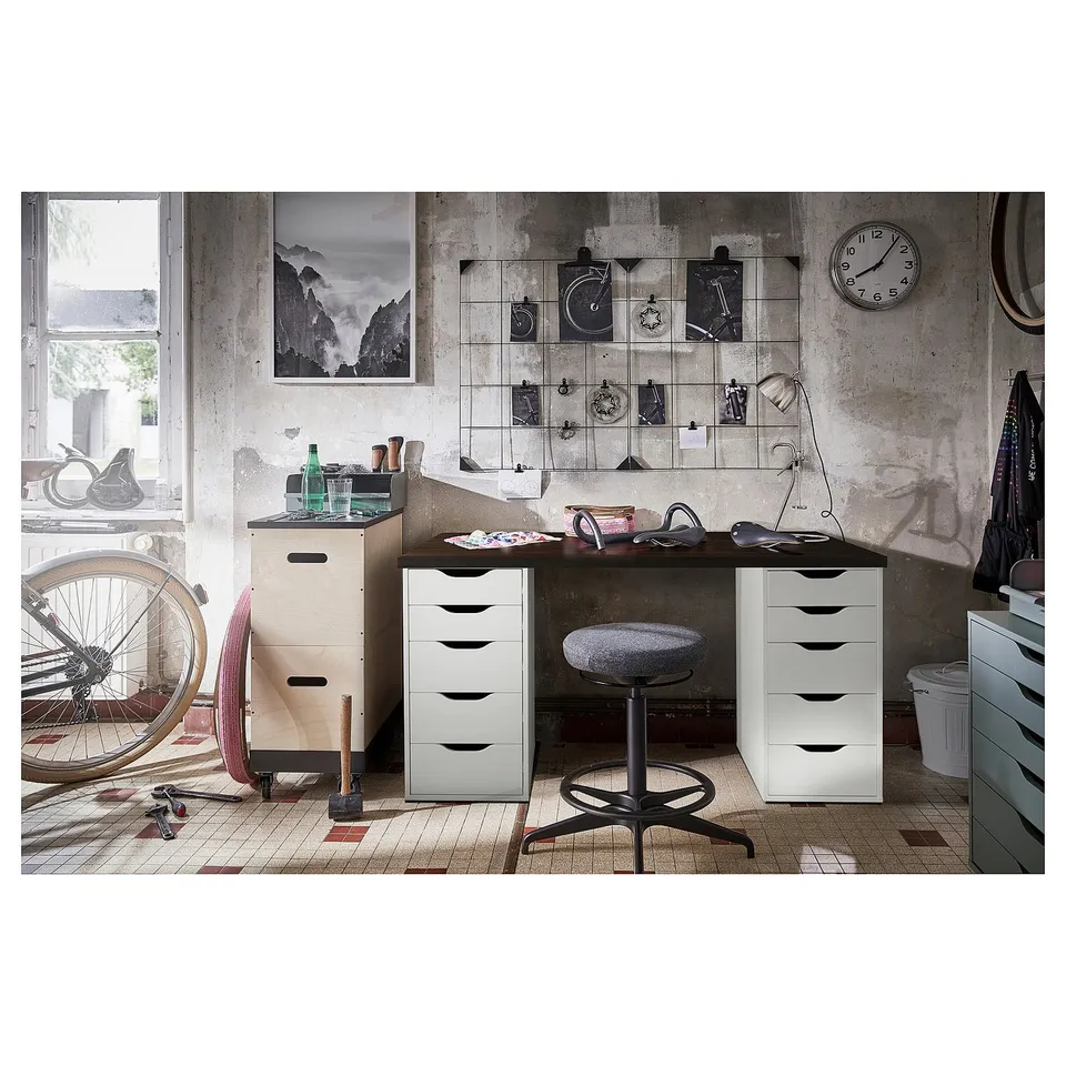 Home office with white desk, black chair, and wall decor.