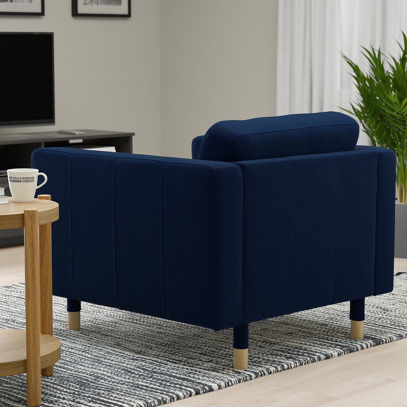 Two blue upholstered armchairs, designed for comfort, with wooden legs, in a cosy living room setting.