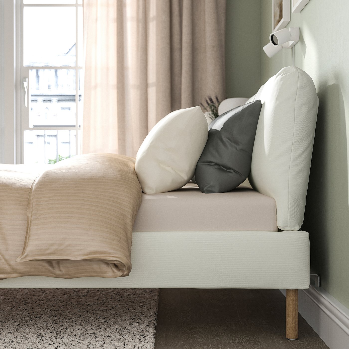 A modern bed frame with two pillows on a sloped headboard, perfect for sitting and reading, positioned near a window with beige curtains.