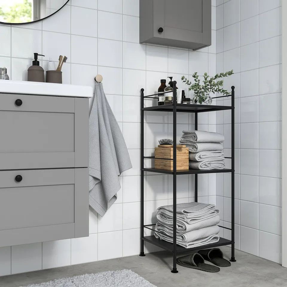 Modern bathroom with grey FRÖSJÖN shelf, towels, toiletries, plant, and vanity.