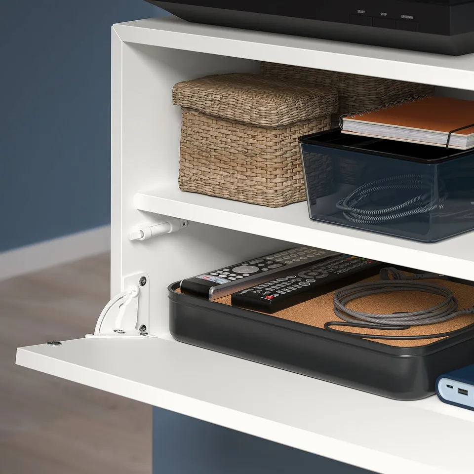 White wall-mounted storage with 3 shelves, baskets, organiser, cables, remote, book, push-open design.