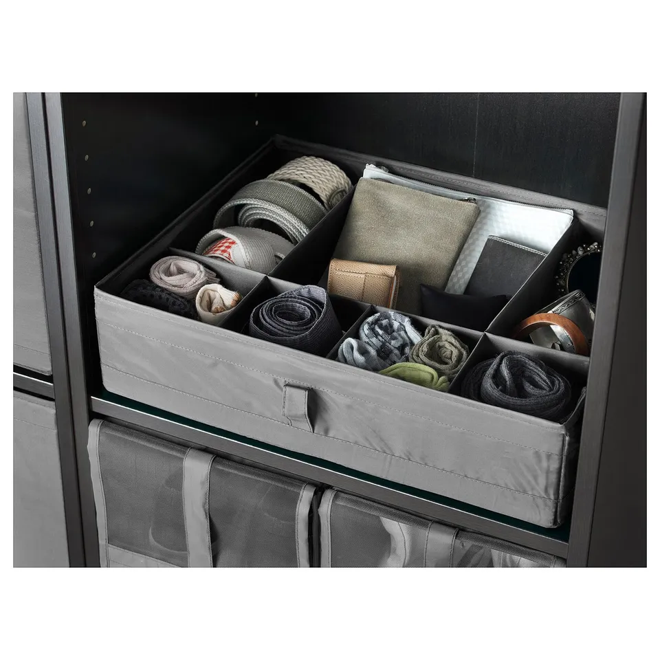 A SKUBB box with folded clothes and accessories in a cabinet drawer, featuring multiple compartments for organisation.