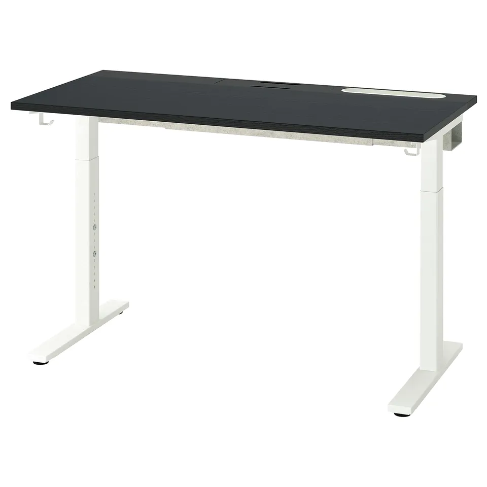 An adjustable MITTZON desk with a black top and white legs. It has a sleek, modern design with cable management slots.