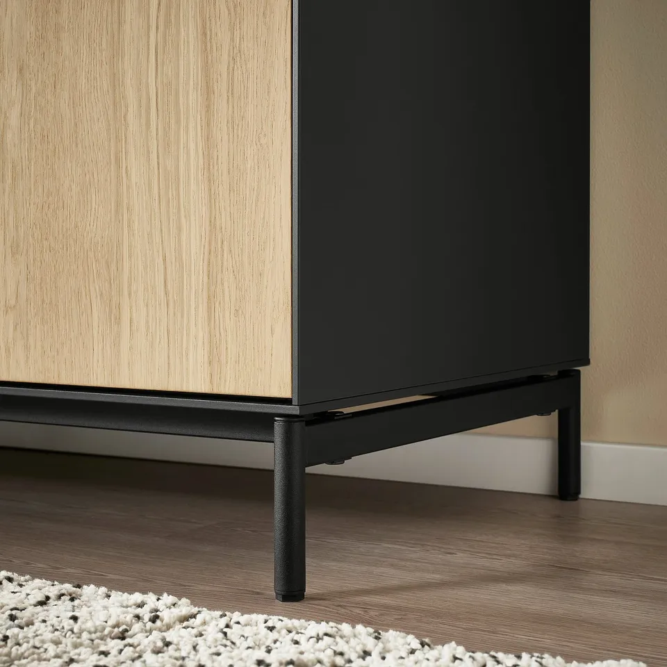 Modern tall cabinet with light wood doors and black metal legs, displaying sleek design and quality craftsmanship.