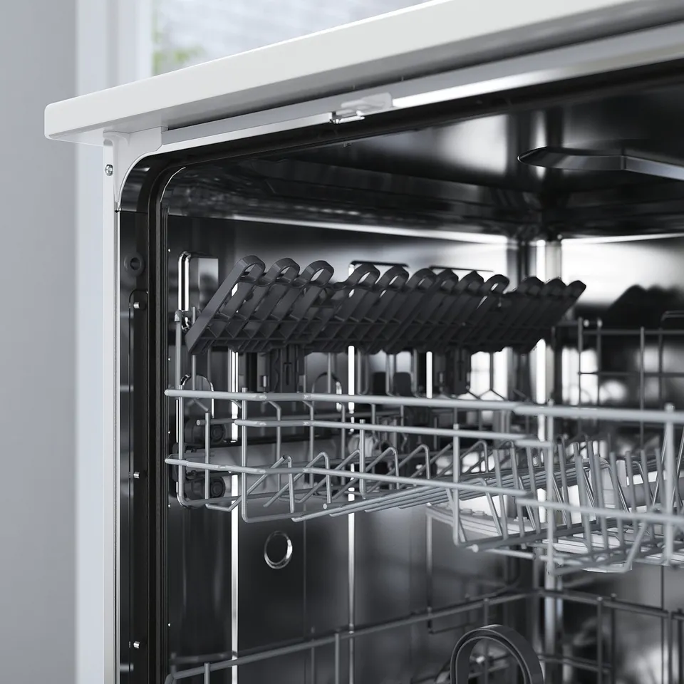 Black-and-white an open dishwasher with its racks empty, showing top and bottom compartments with steam prevention adhesive.