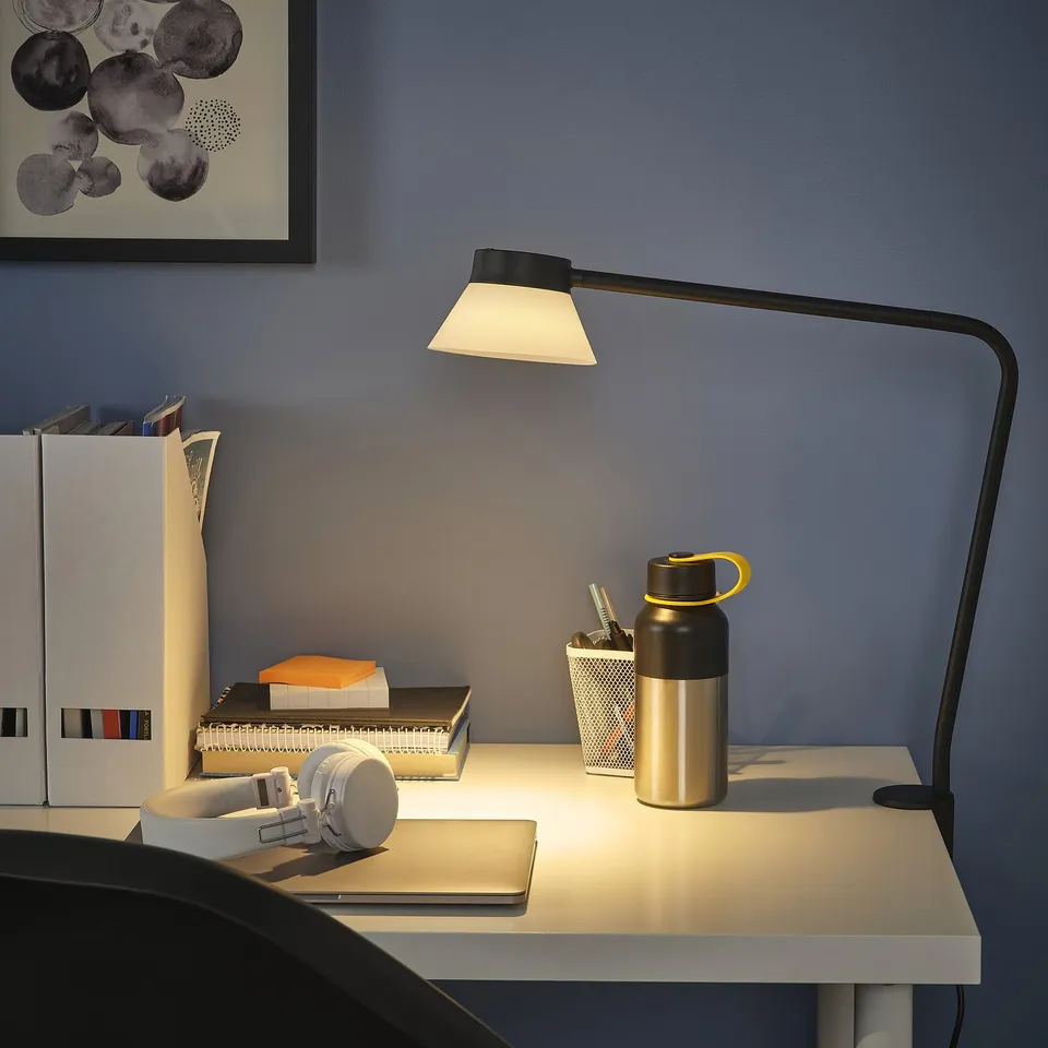 SAMBORD lamp clamped on desk, offering focused light and compact design.