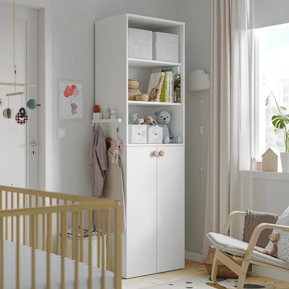 Nursery with white ALTARLIDEN steel hook rack for storage, between crib & window.