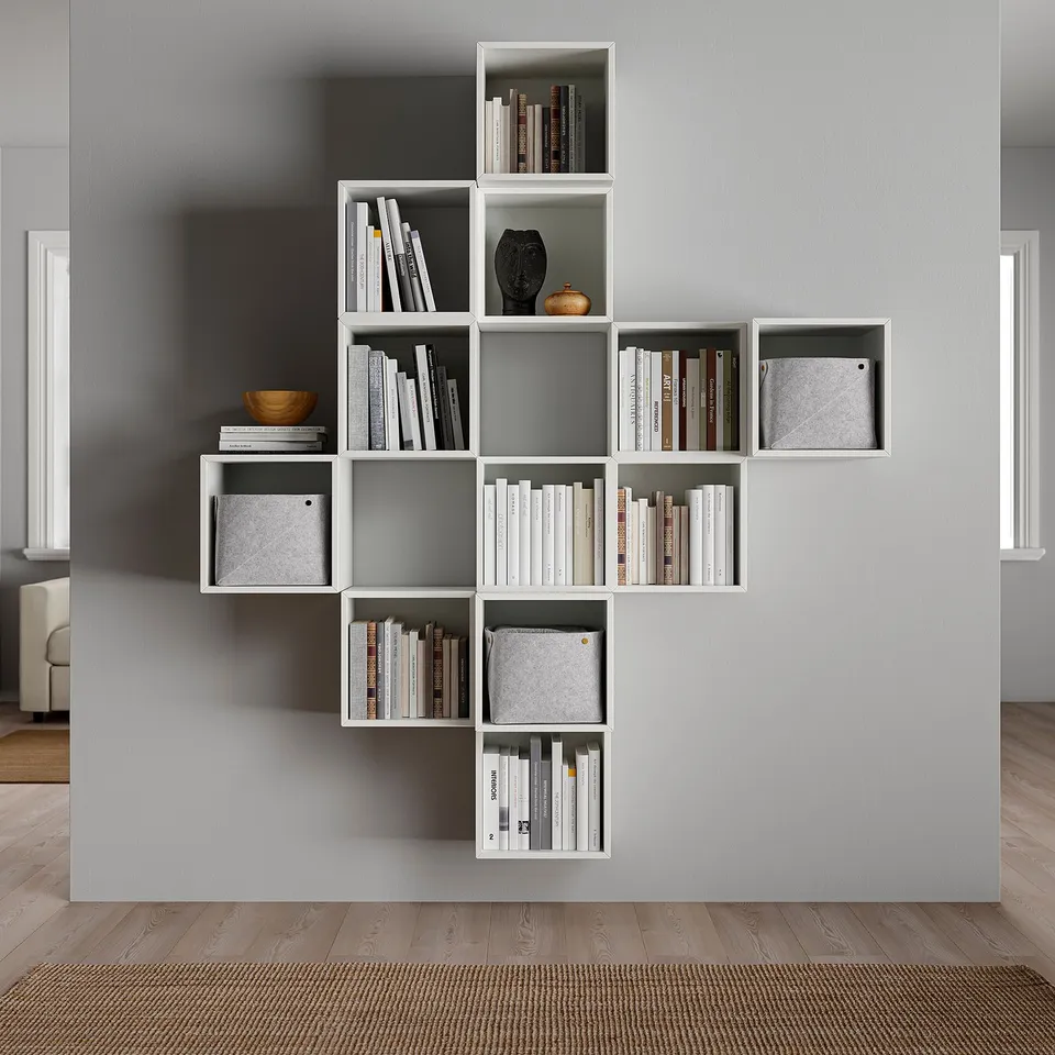 Elegant white wall-mounted bookshelf named EKET, featuring varying cubed compartments for storing books and decorative items.