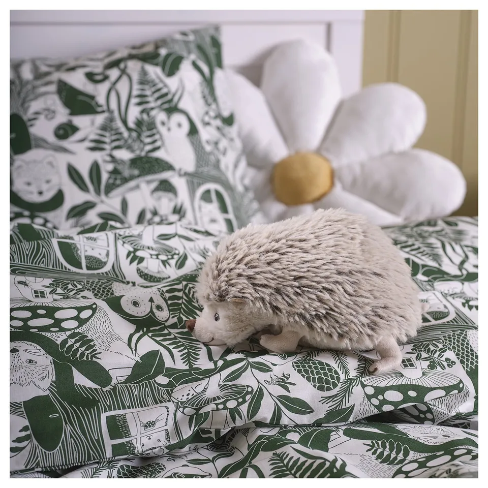 SKOGSDUVA grey hedgehog toy on green patterned bedding, small, plush, flowers and creatures.