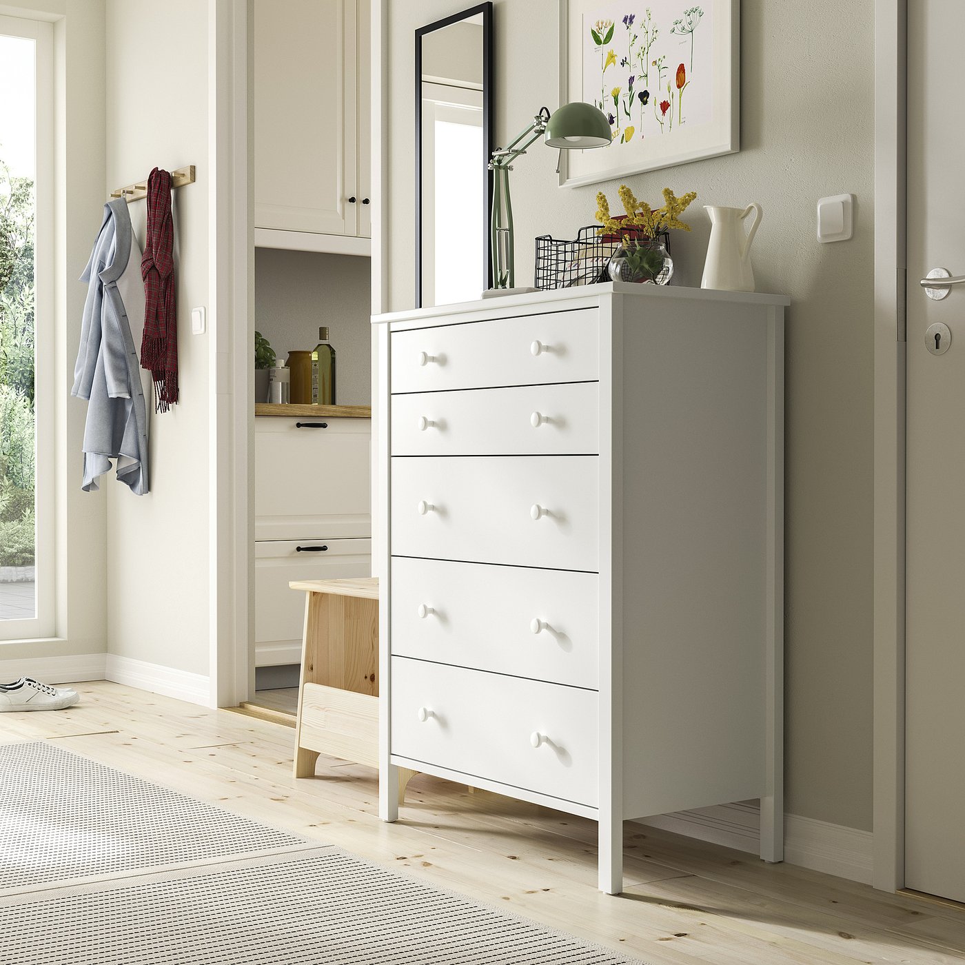 White chest with 5 drawers, tall, simple design. Near hooks, stool, narrow cabinet, rug.