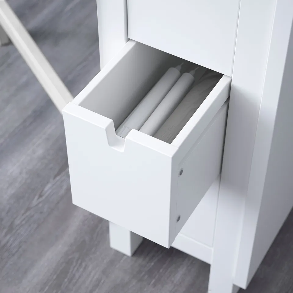 A white drawer unit with three rolls of paper inside. The drawer is open, revealing the storage space designed to hold the rolls neatly.