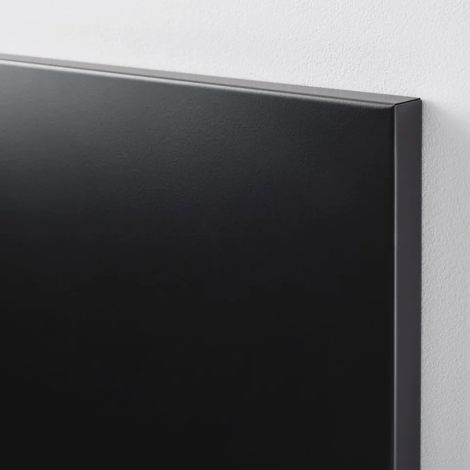 Black magnetic memo board mounted on a wall, showing its high-quality, flat surface and sleek frame.