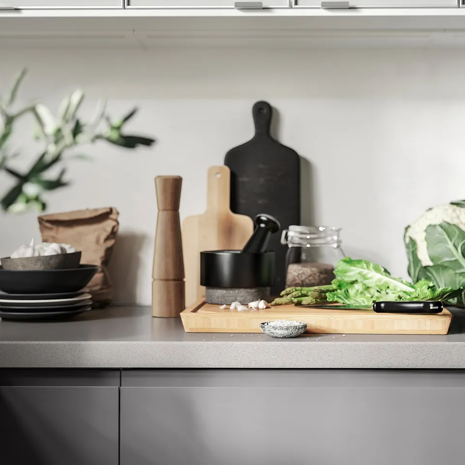Modern kitchen counter with tools, ingredients, and ÄDELSTEN mortar.