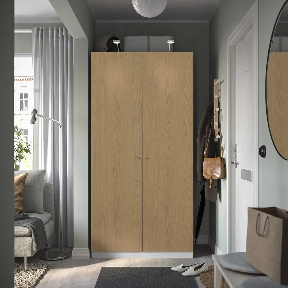 Modern entryway, tall PAX wardrobe, coat rack, white door, grey rug.