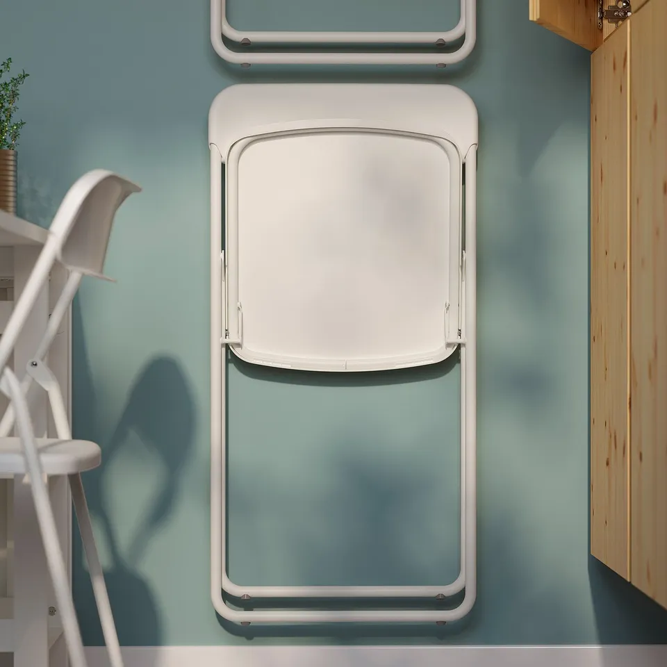 White folding chairs mounted on light blue wall, space-saving design.