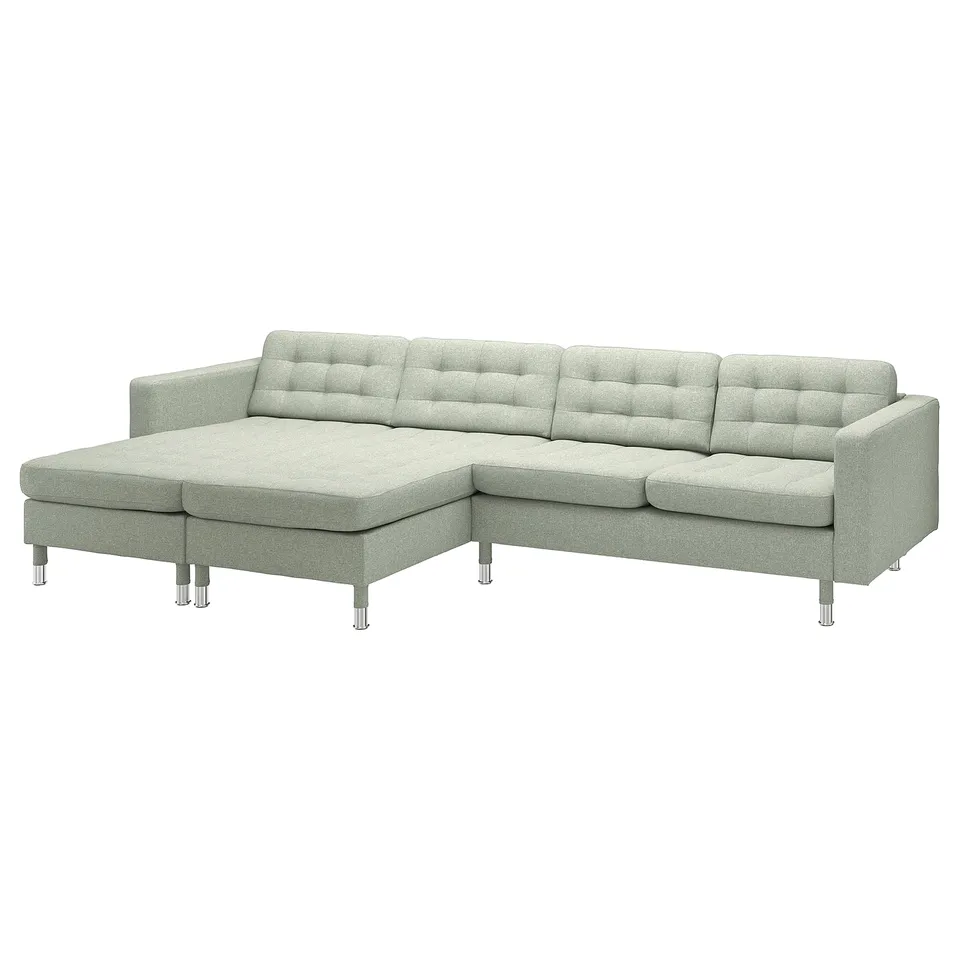 Modern l-shaped green sofa, chrome legs, padded cushions.
