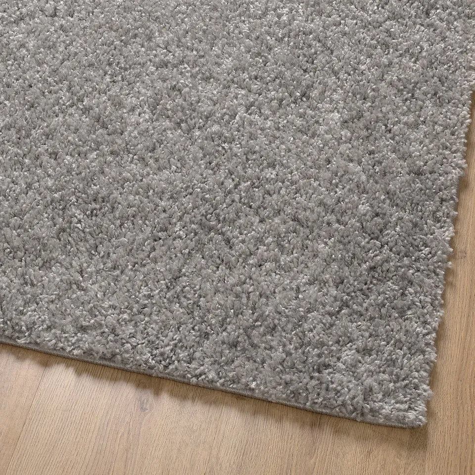 Soft, plush grey area rug with thick pile for comfort. Ideal for living spaces, dampens sound.