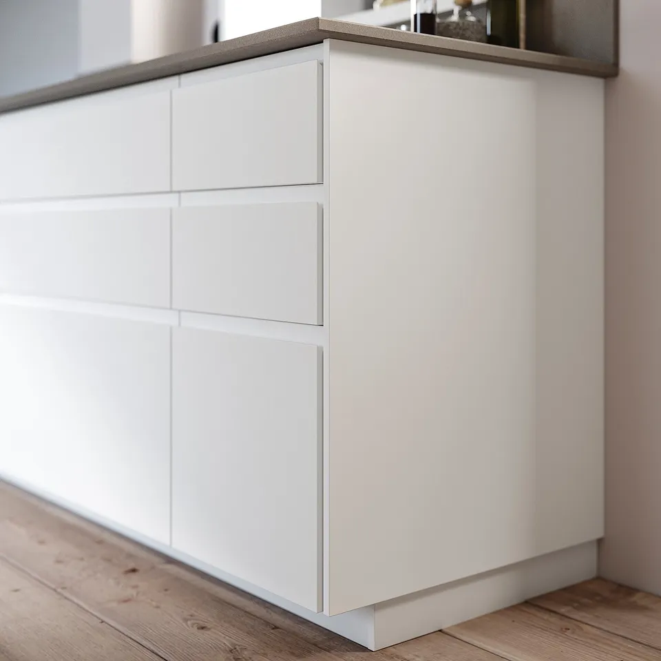 White modern kitchen island with clean lines and cream tones, featuring sleek drawer design.