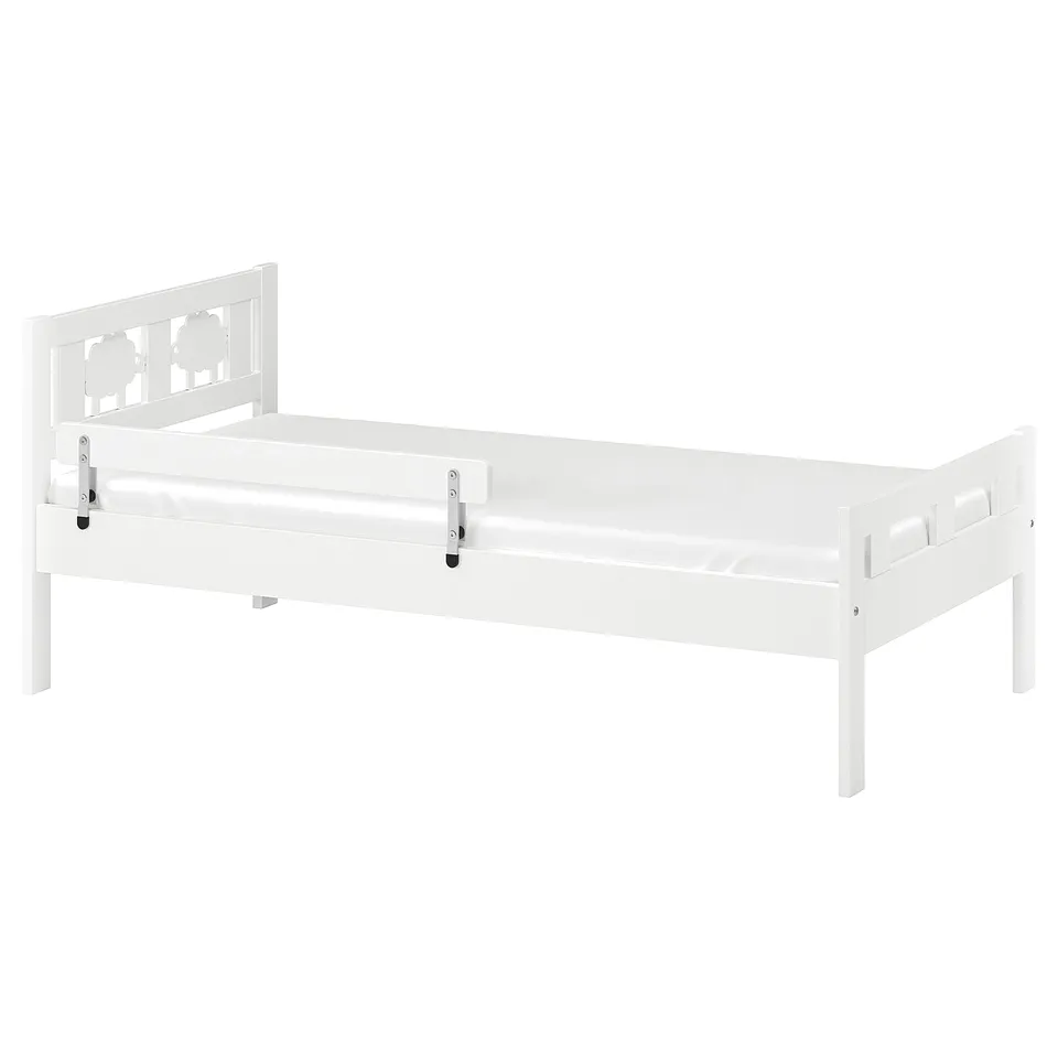 A white KRITTER toddler bed with safety rail, simple design, made of fiberboard and polystyrene plastic.