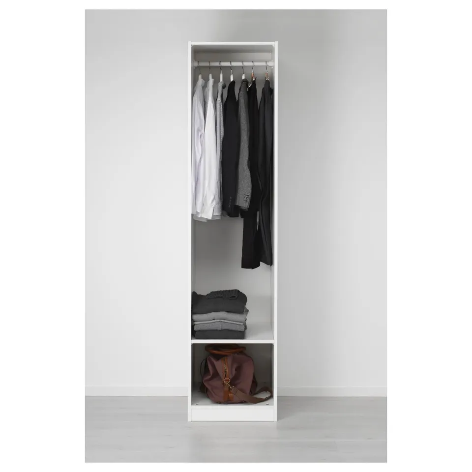 Open wardrobe with clothes hangers and folded sweaters, bag on bottom shelf.