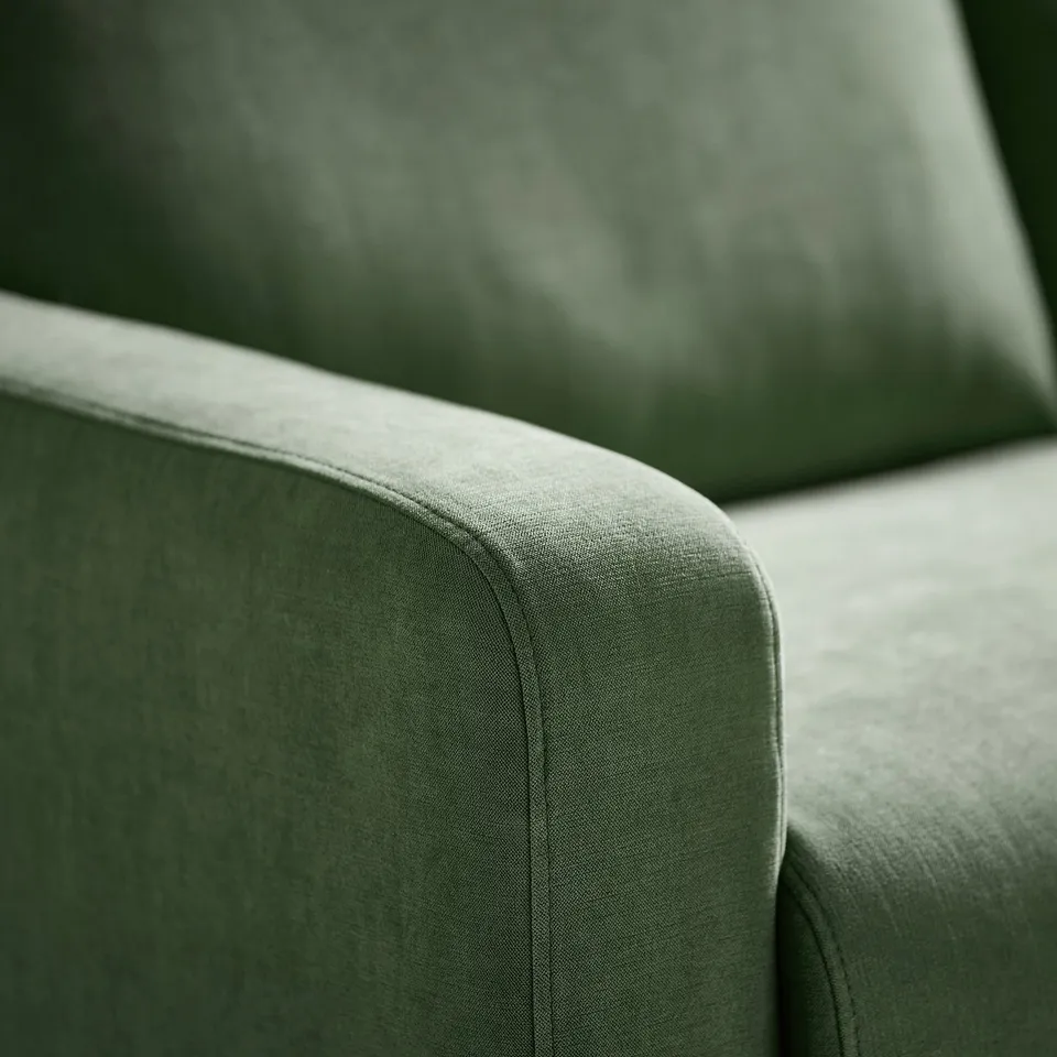 Close-up of a soft, green GULLVALLA sofas armrest, showcasing its plush, textured fabric and rounded design for comfort.
