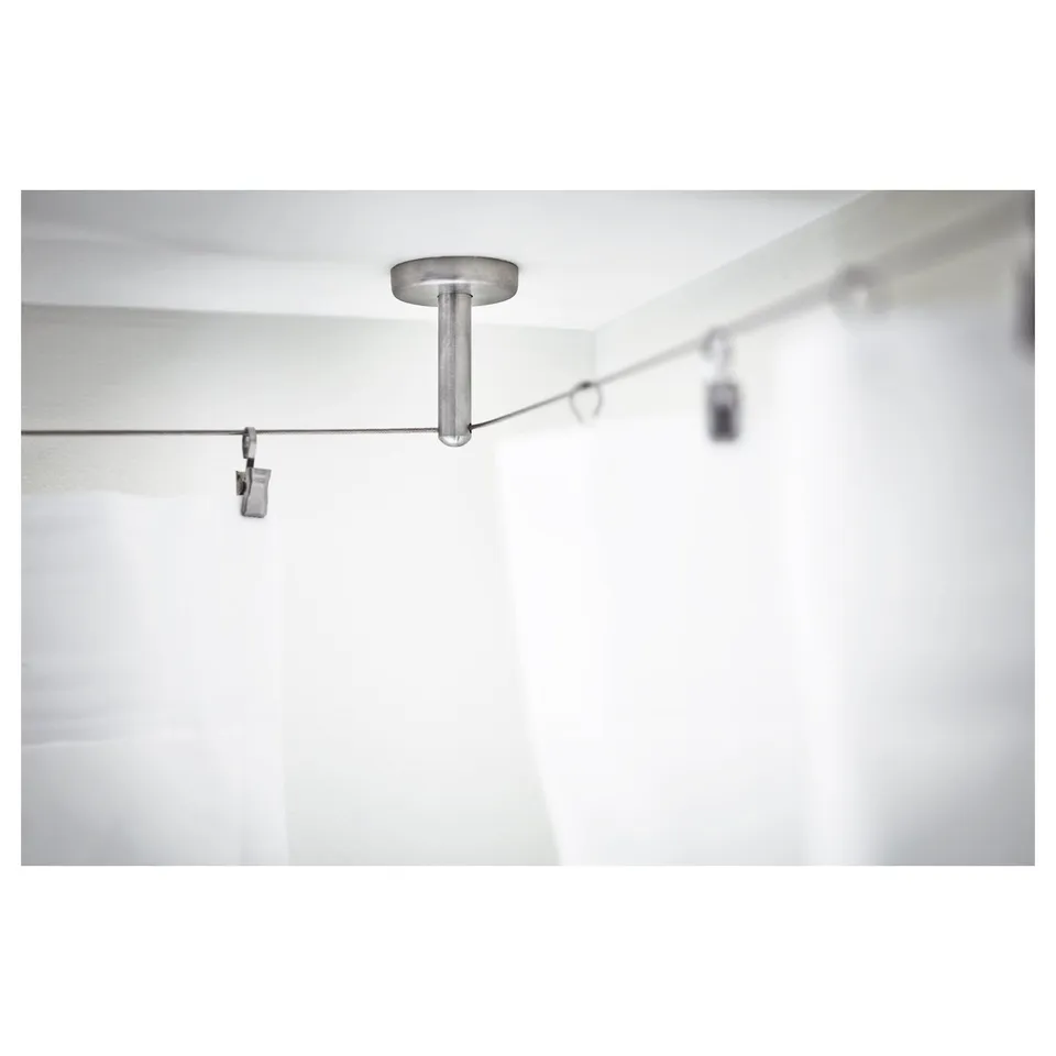 A ceiling-mounted curtain wire support fitting. This adjustable component is designed for flexible use and stability in longer curtain wires.
