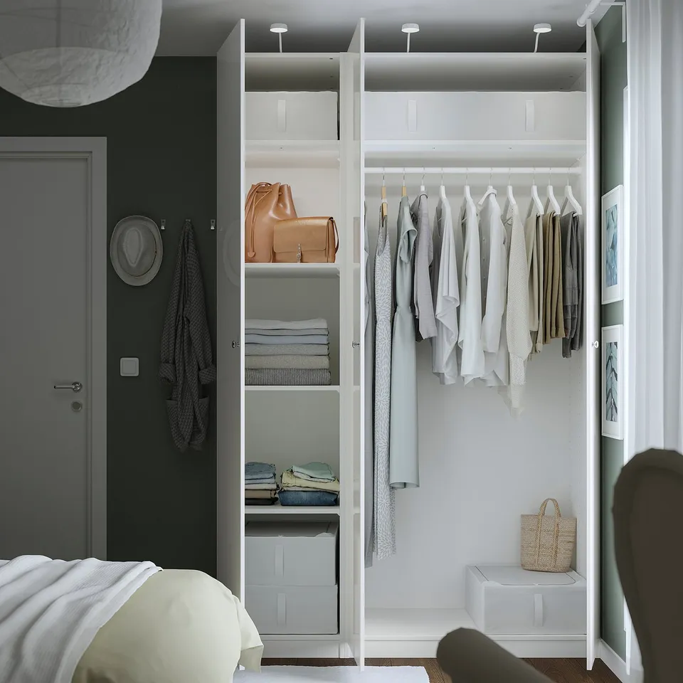 Open closet with clothes and bags on hangers and shelves, lit by ceiling lights.
