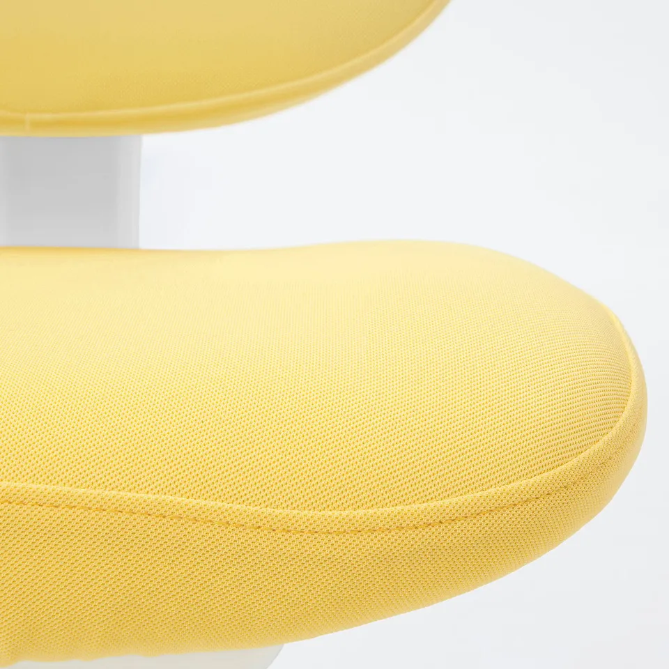 Close-up of bright yellow circular chair cushion with textured fabric and white base, showcasing modern design.