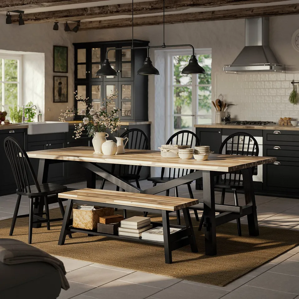 Wooden dining table with black chairs, pendant lamp, dishes, and natural light.