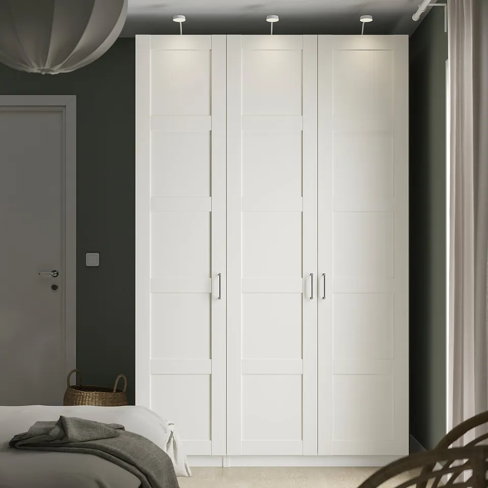 Modern bedroom with BERGSBO white wardrobe. Tall, rectangular, minimalist design. Soft-close doors, large near window.