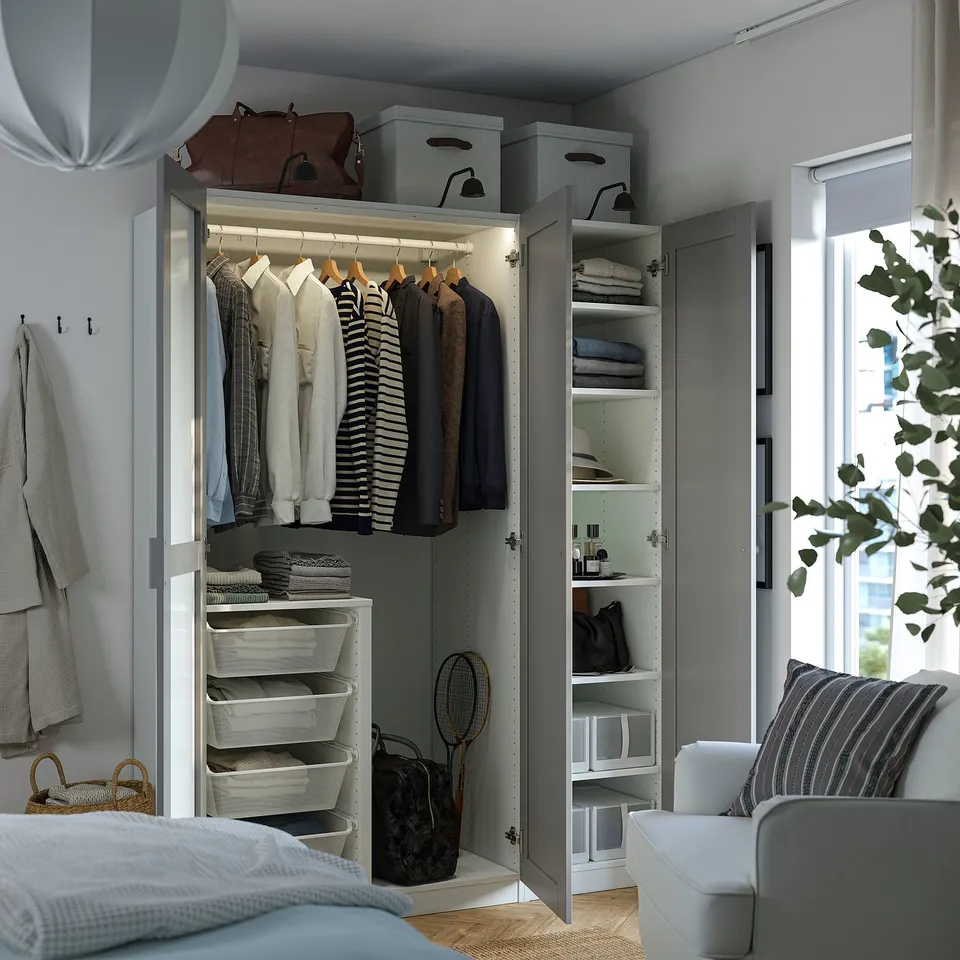 Open closet revealing clothes hangers, foldable clothes, and storage bins.