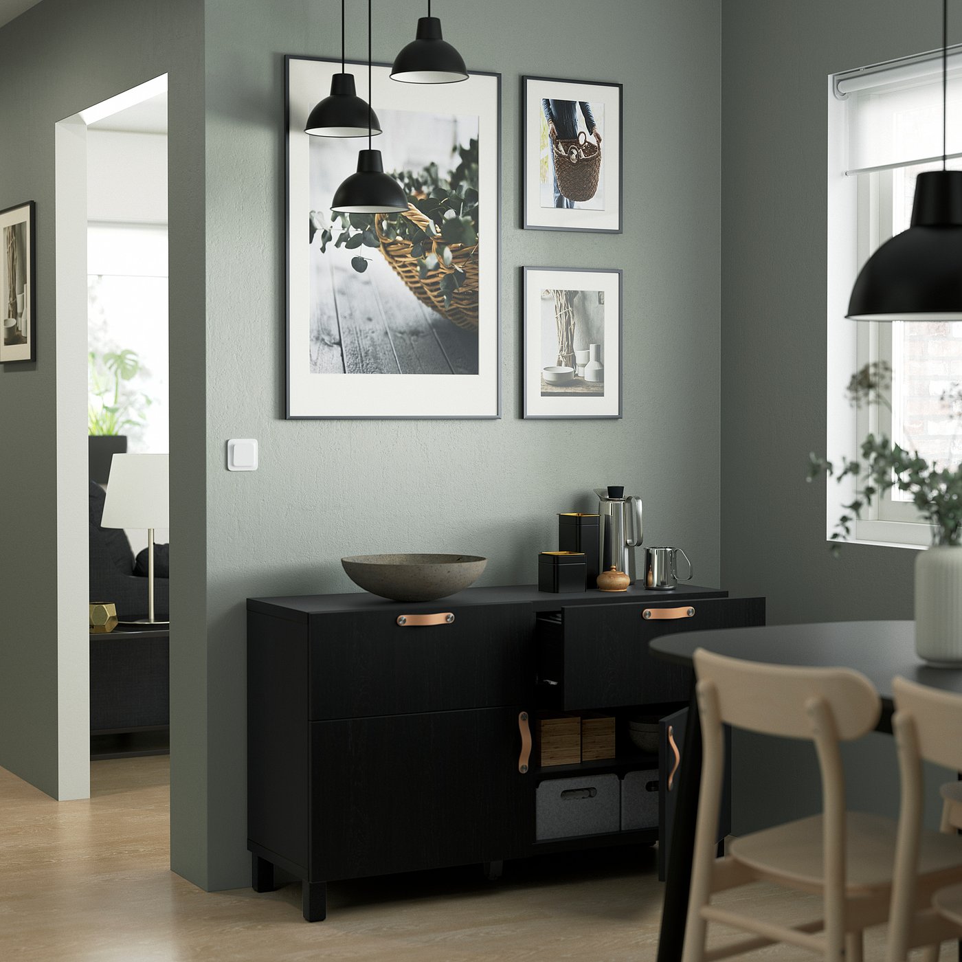 Modern dining room with black BESTÅ sideboard, decorative bins, art, and stone bowl.
