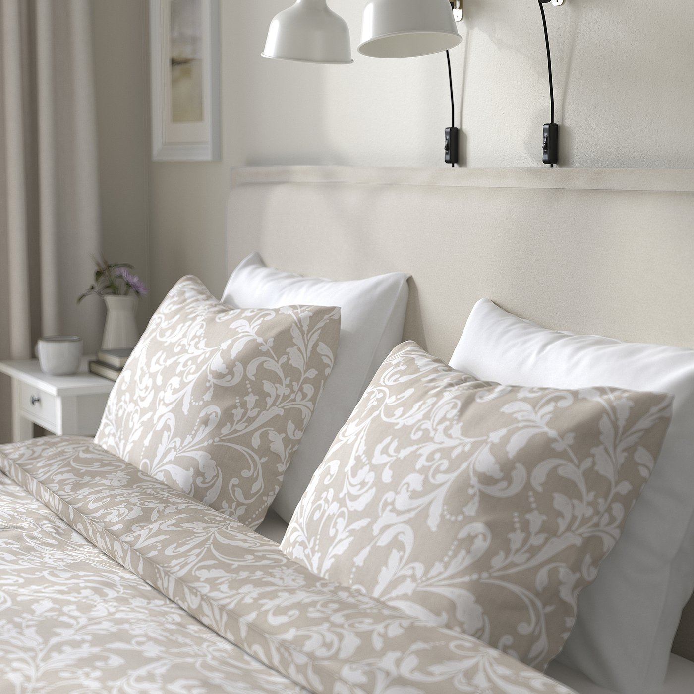 Bed with floral bedding, pendant lights, bedside table with flowers.