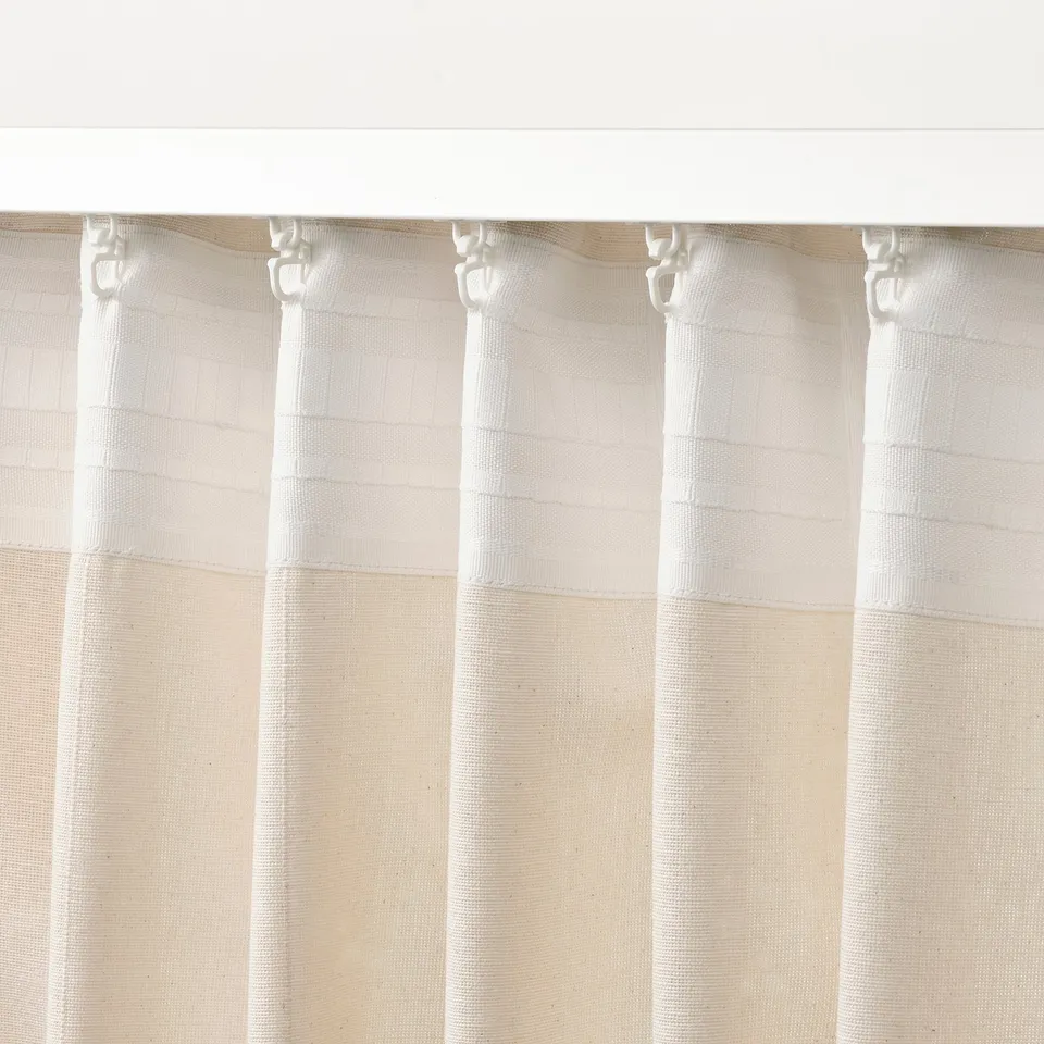 Off-white curtains with header tape for easy hanging. Curtains hang neatly with linear weave, suitable for privacy and daylight control.