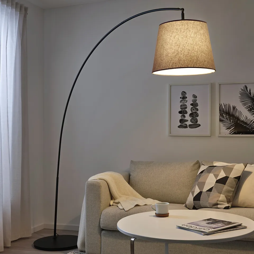 Cosy living room corner with SKOTTORP lamp, sofa, coffee table, & artwork.