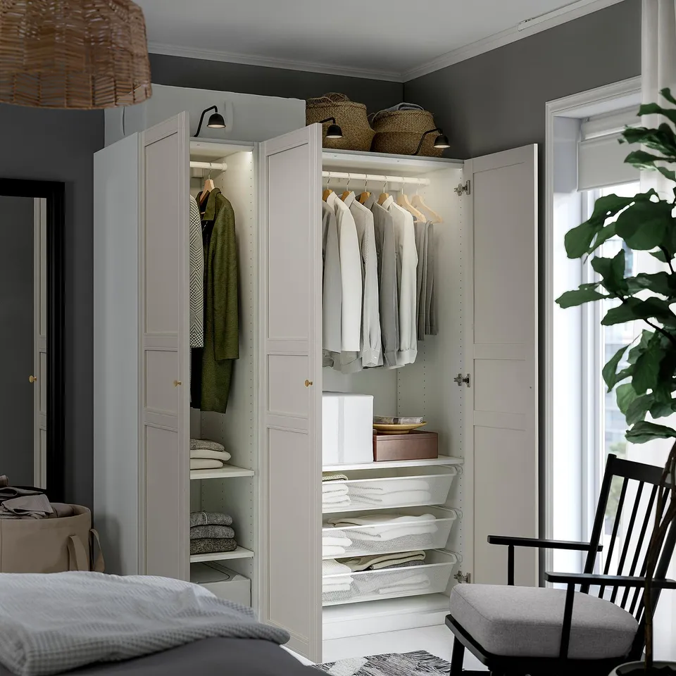 A modern closet: PAX, featuring hanging clothes, shelves, and storage bins. Soft-closing hinges ensure safe and silent door operation.