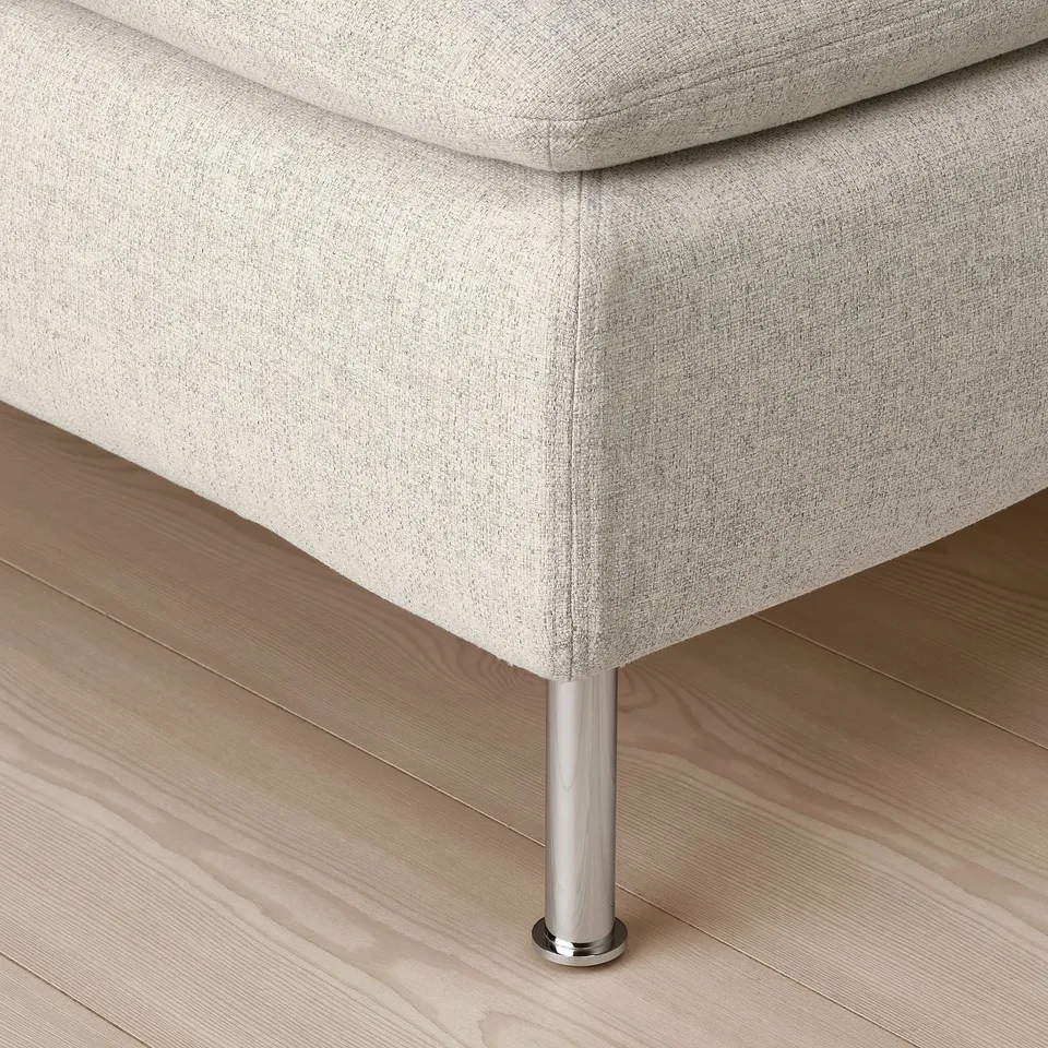 Close-up of modern sofa leg, sleek chrome finish, clean light fabric upholstery.