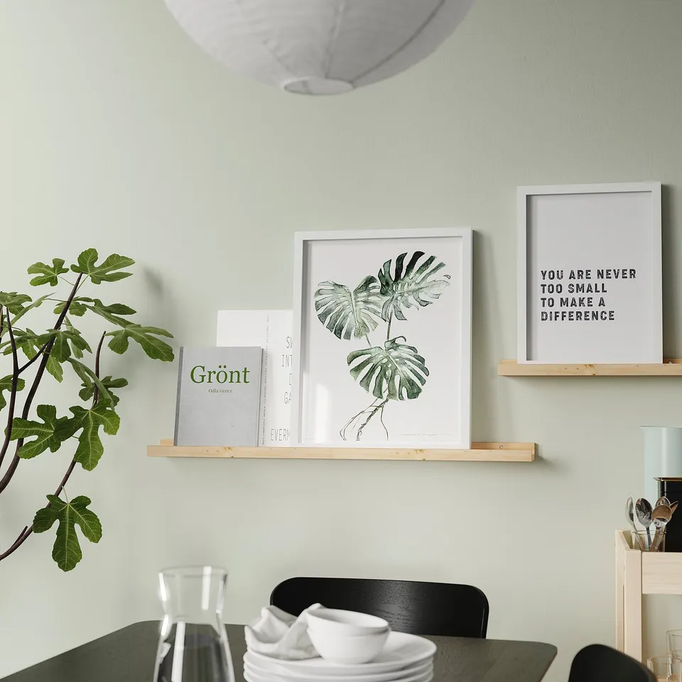 Minimalist dining space with hemlock shelf holding photos, plant, and dishware.
