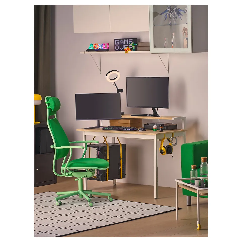 Modern gaming setup with white desk, green chair, 2 screens, led lamp, headphones, and accessories.
