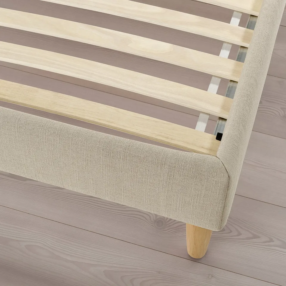 Modern bed frame with slatted headboard and beige upholstery, showcasing quality craftsmanship.