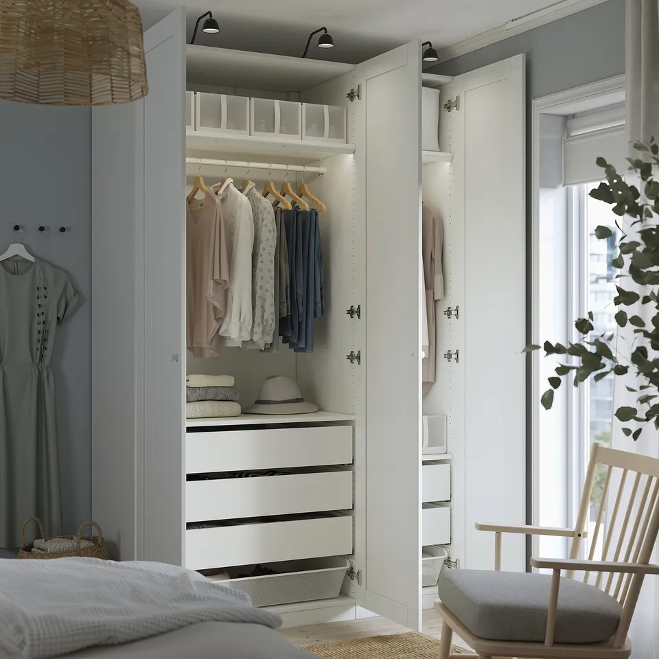 Modern bedroom with open closet displaying clothes and accessories, including adjustable feet and dampened hinges.