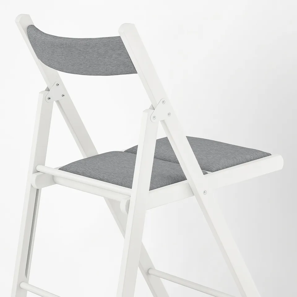 Foldable white chair with grey fabric seat and back, modern design, sturdy frame.