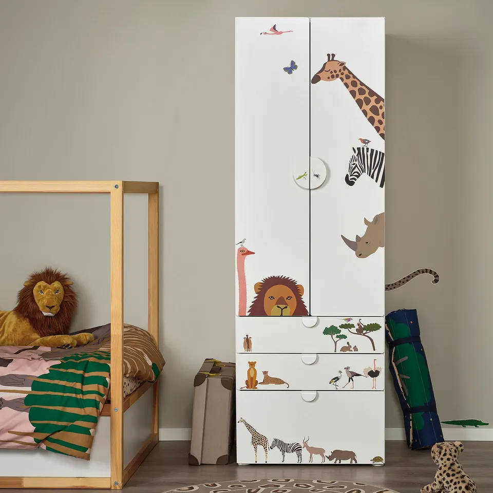 Kids room with wooden bed, cabinet adorned with safari stickers, and a stuffed lion toy.