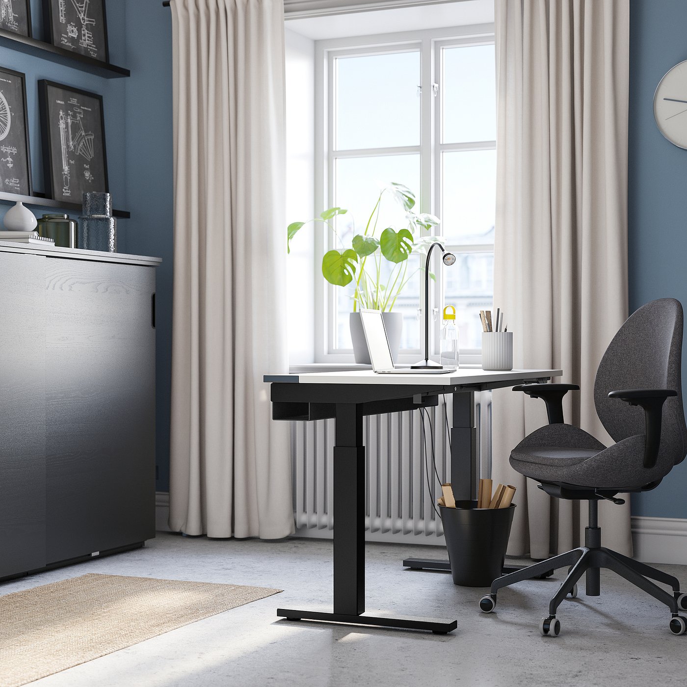 Modern home office with MITTZON desk, chair, laptop, lamp, plant, and bookshelf.